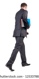 Back View Of Walking  Business Man With Books. Going Young Guy In Black Suit. Isolated Over White Background. Rear View People Collection. Backside View Of Person