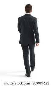 Back View Of Walking Businessman In Black Suit. Isolated On White Background