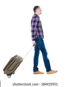 Back View Walking Man With Suitcase. Brunette Guy In Motion. Backside View Person.  Rear View People Collection. Isolated Over White Background. Young Man Goes To Side Of Rolling Travel Bag On Wheels