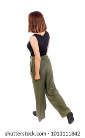 Back View Of Walking  Woman. Beautiful Blonde Girl In Motion.  Backside View Of Person.  Rear View People Collection. Isolated Over White Background. Top View Of A Girl In Green Trousers Walking Sidew