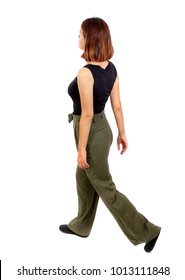 Back View Of Walking  Woman. Beautiful Blonde Girl In Motion.  Backside View Of Person.  Rear View People Collection. Isolated Over White Background. Top View Of A Girl In Green Trousers Leaving In