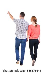 Back View Of Walking Young Couple (man And Woman) Pointing. Rear View People Collection. Backside View Of Person. Isolated Over White Background