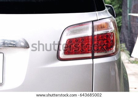Back view of white car. White car and taillight. White car parked in the parking lot. White car for transportation.