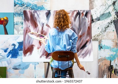 Back view woman artist is drawing abstract picture in workshop studio gallery. Process of creating brown beige oil, watercolor, acrylic painting at creative workplace. Contemporary modern art concept. - Powered by Shutterstock