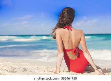 Back View Of Woman In Bikini Relaxing At White Sand Beach