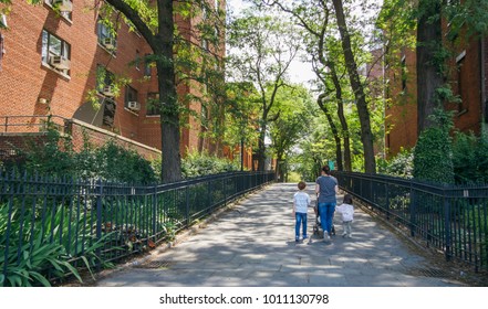 Back view of woman with children walking by pedestrian street in Brookyn district, in New York City