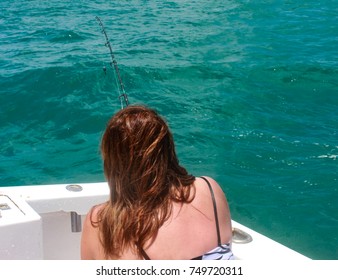 Back View Of Woman Fishing On Deep Sea Fishing Boat