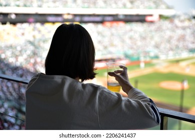 Back View Of Woman Holding Beer At Baseball Field