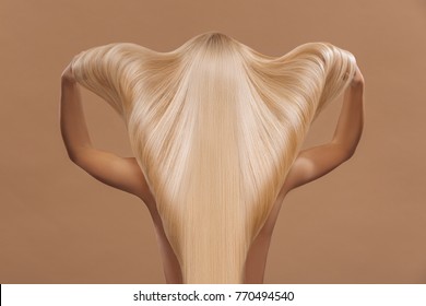 Back View Of Woman With Long Beautiful  Blond  Hair, Isolated On Brown, Haircare Concept