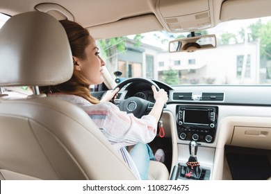 Back View Of Woman Looking Away While Driving Car