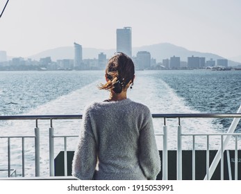 Back view of a woman looking at the scenery from the ferry