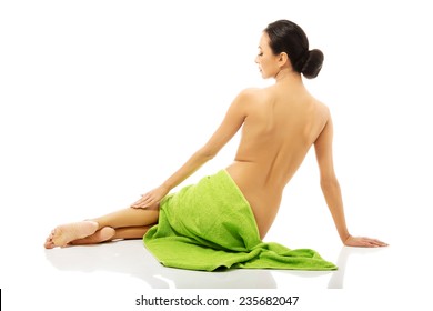 Back View Of Woman Lying Wrapped In Green Towel