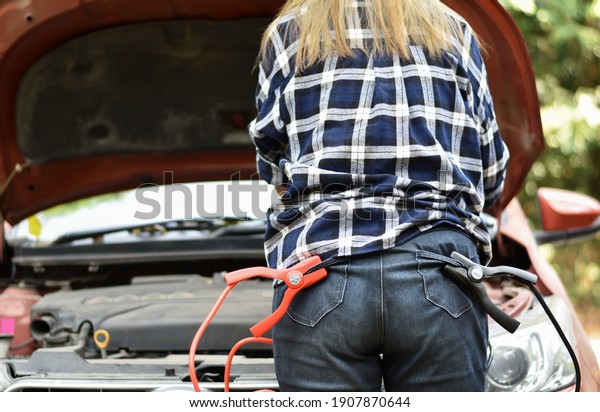 Back view of women, Check the terminals of\
personal car batteries.