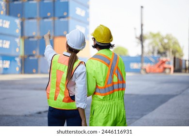 back view workers looking and pointing above in containers warehouse storage