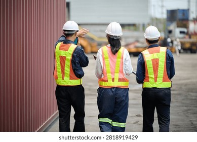 Back view workers walking and inspecting cargo containers