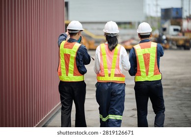 Back view workers walking and inspecting cargo containers