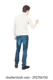 Back View Of Writing Man. Young Man In Jeans Draws. Rear View People Collection.  Backside View Of Person. Isolated Over White Background.  The Guy In White Sweater Draws Felt-tip Pen On The Wall.