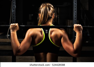 Back view young adult girl doing barbell squats in gym. Woman with muscular body doing lifting exercise. - Powered by Shutterstock