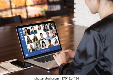 Back view of young asian business woman work remotely at home video conference remote call to corporate group. Meeting online,videocall, group discuss online concept with screen of teamwork on laptop. - Shutterstock ID 1704314434