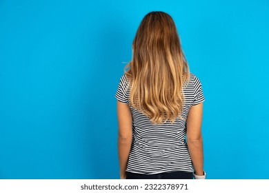 The back view of a Young beautiful woman wearing striped t-shirt. Studio Shoot. - Powered by Shutterstock