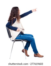 Back View Of Young Beautiful  Woman Sitting On Chair And Pointing.  Girl  Watching. Rear View People Collection.  Backside View Of Person.  Isolated Over White Background.