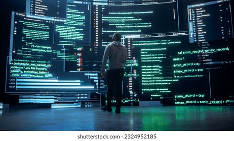 Back View of Young Black Man Walking and Looking at Big Digital Screens Glitching While Displaying Code Lines. Professional Hacker Breaking Through Cybersecurity Protection System, Changing Code - Powered by Shutterstock