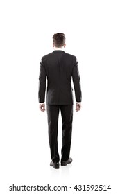 Back view of young businessman in black suit isolated on white background