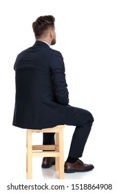 back view of young businessman thinking, sitting isolated on white background in studio