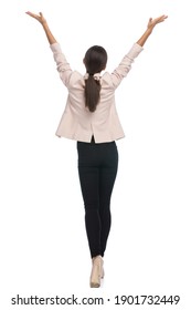 back view of young businesswoman in pink jacket holding arms in the air and cheering, walking isolated on white background in studio