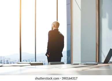 Back View Of Young Confident Man Leader Is Resting After Business Meeting With Foreign Partners, While Is Standing Near Big Office Window Background With Copy Space For Your Advertising Text Message