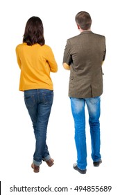 Back view of young couple man and woman hug and look into the distance. beautiful friendly girl and guy together. Rear view. Isolated over white background. young woman holds the hand of her husband