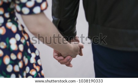 Back view of young couple walking outdoor holding hands. Clip. - love, relationship, everyday life concept