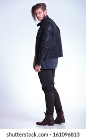 Back View Of A Young Fashion Man In Leather Jacket Looking At The Camera