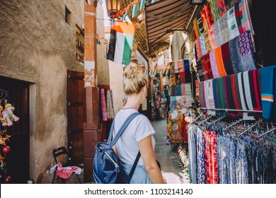 Back view of young female traveller at traditional bazaar in Dubai, UAE