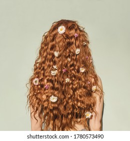 Back View Of Young Ginger Curly Girl With Flowers In Hair. Concept Of Spring And Summer Youth Happiness. Green Background.