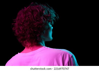 Back View Of Young Hairy Man, Student In White Tee Isolated On Dark Background In Neon Light. Concept Of Emotions, Facial Expression, Youth, Aspiration, Sales And Ad