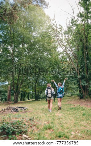 Similar – Hiker woman with backpack raising her arms into the forest