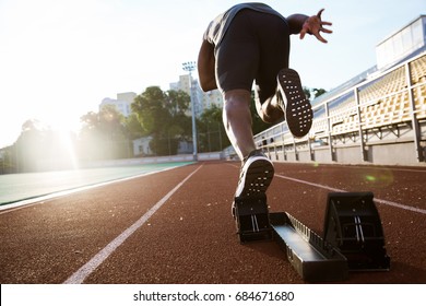 Back view of a young male athlete launching off the start line in a race - Shutterstock ID 684671680