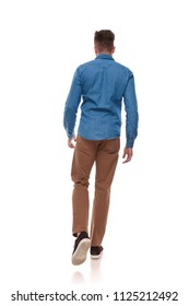 back view of young man in casual clothes walking on white background, full length picture