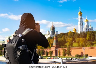 Back view of young man photographer using a camera takeing a picture of view in Kremlin palace, Moscow,Russia