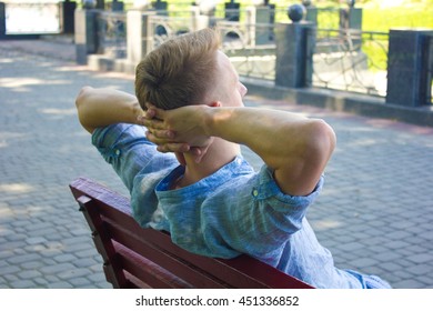Back view of young man resting in the park