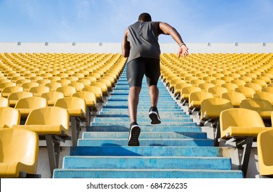 Back View Of A Young Man Running Upstairs At A Stadium