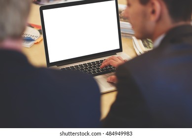 Back View Of A Young Manager Is Using Laptop Computer With Copy Space Screen For Your Advertising Text Message Or Promotional Content. Man Is Working On Net-book During Training In Business School