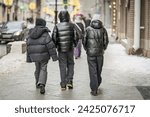 Back view of Young Men Walking in Urban Setting in winter. Modern city life. Candid Street Photography