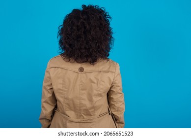 The Back View Of A Young Pregnant Arab Woman Standing On Blue Studio Background  . Studio Shoot.