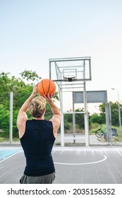 Back View Young Sporty Muscular Strong Caucasian Sportsman Man 20s In Sports Clothes Training Shooting Free Throw Play With Ball At Basketball Game Playground Court Outdoor Courtyard Sport Concept.