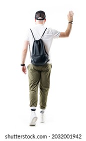 Back View Of Young Stylish Man With Black Bag Walking Away Waving Hand Goodbye. Full Length Portrait Isolated On White Background