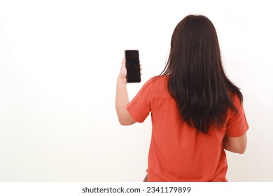 Back view of young woman standing while holding a cell phone. Isolated on white - Powered by Shutterstock