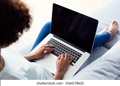 Back View Of Young Woman Using Laptop While Sitting On Sofa