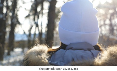 Back View Of Young Woman Walking In Winter Forest At Sunny Day. Unrecognizable Girl Enjoying Stroll Through Snowy Wood. Carefree Lady Going And Admiring Beautiful Winter Landscapes. Slow Mo Close Up